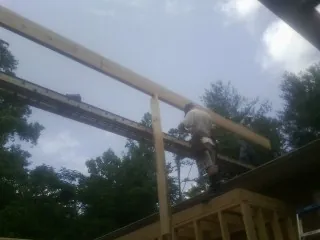 Carpenter setting a ridge beam over a new addition frame — Ice Dam Removal by Roofing Brothers in Denville
