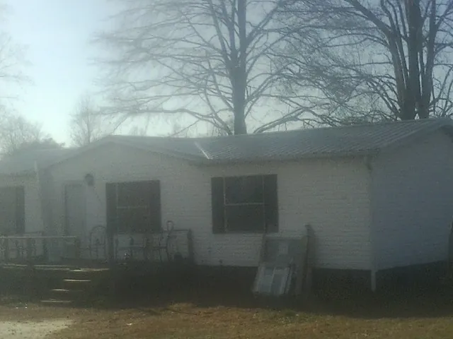 New metal roof on a white painted brick home on a foggy morning in Denville