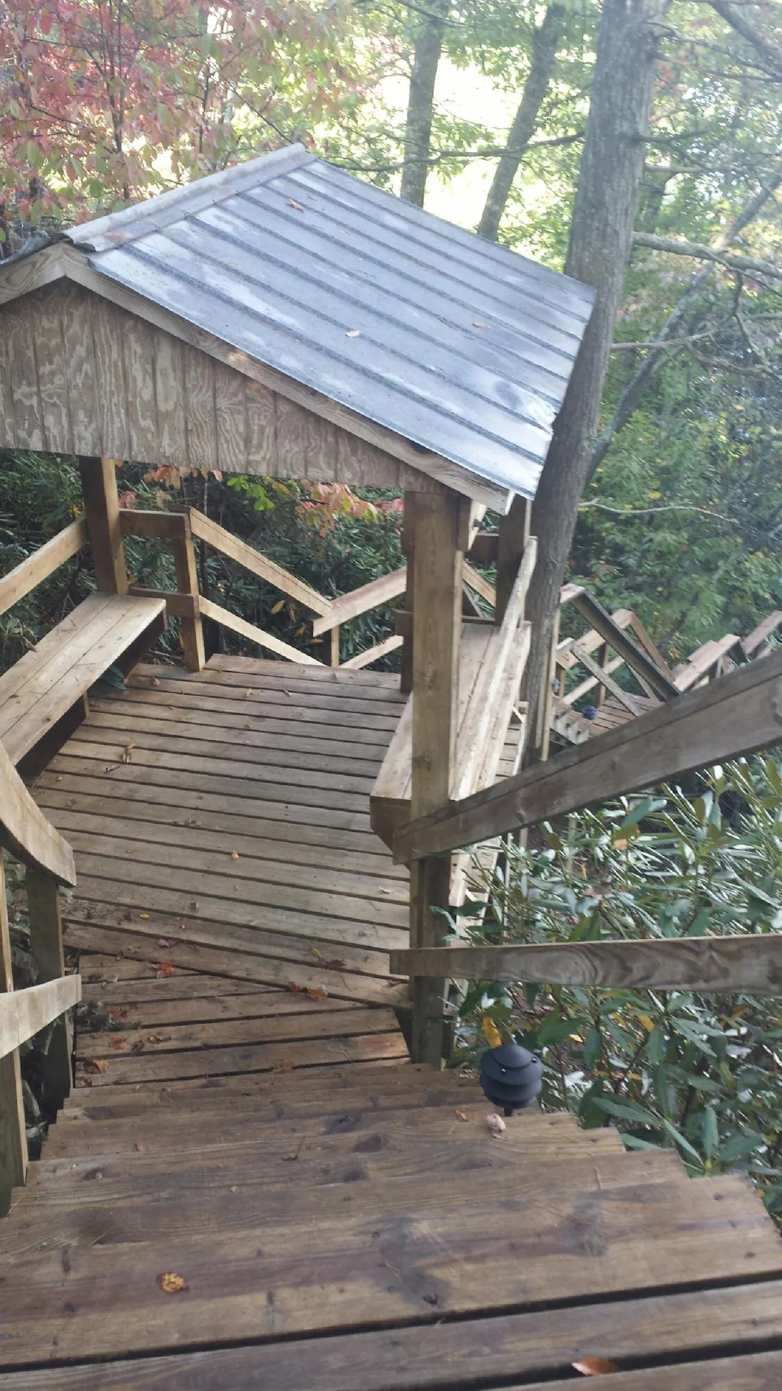 Metal roofed shelter over wooden steps on a wooded walkway — Skylight Repair & Installation work by our crew in Denville