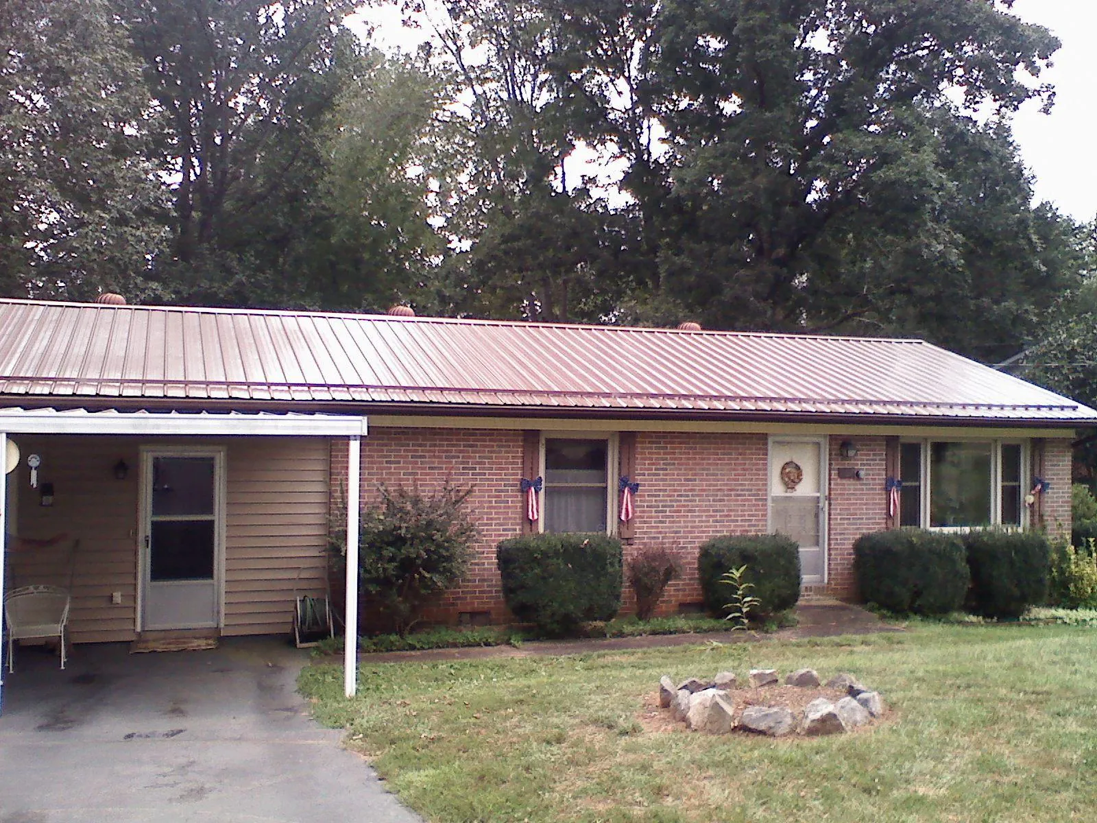 Bronze metal roof and carport on a brick ranch home — Roof Repair work by our crew in Denville